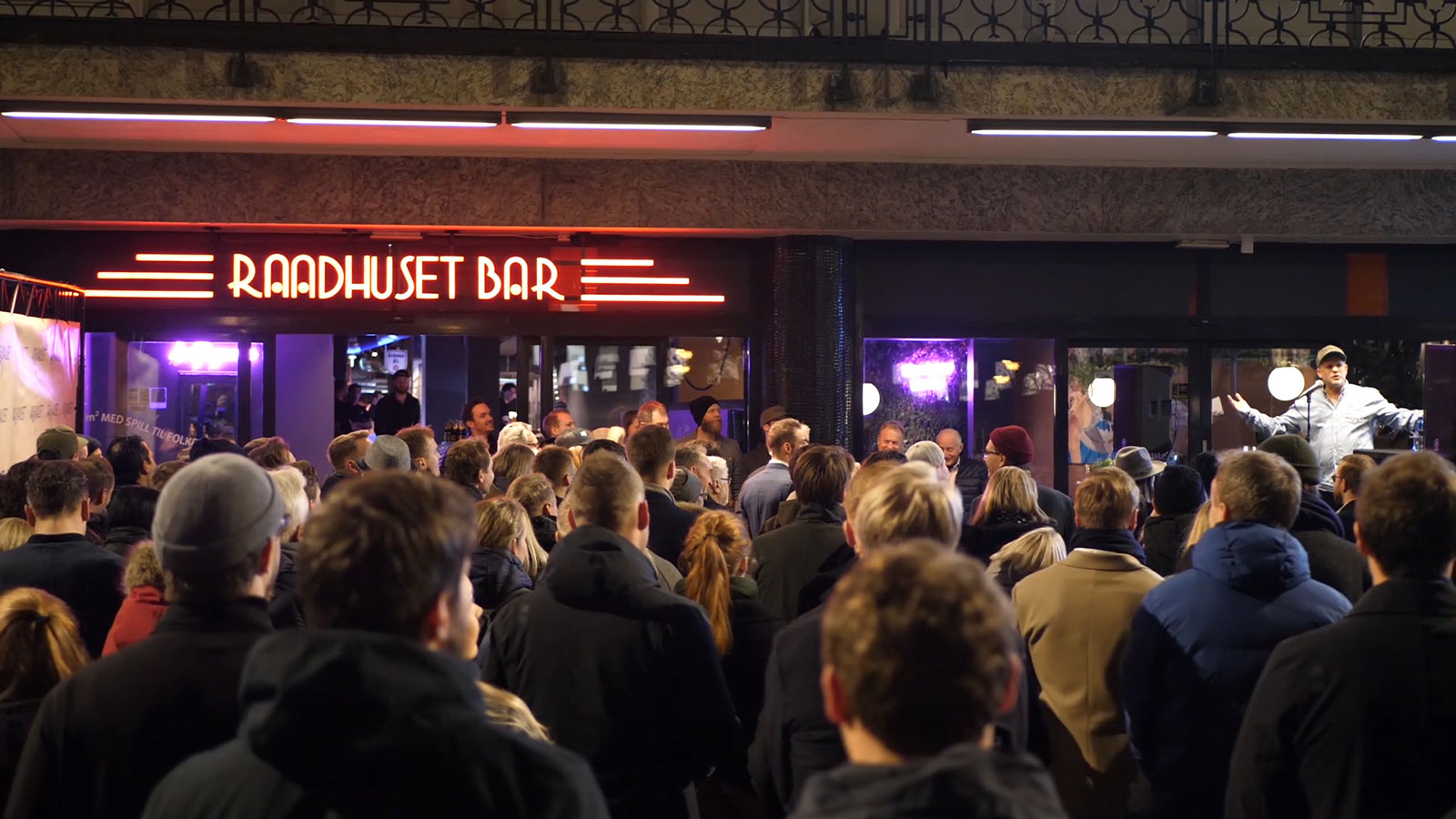 Bilde av inngangen til Raadhuset bar, masse folk utenfor på kveldstid, skiltet lyser opp